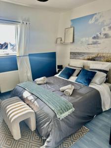 a bedroom with a large bed with a blue wall at La belle échappée, maison chic près de lille & Parc Barbieux in Roubaix