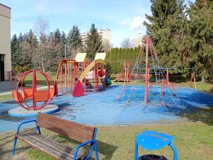 a playground in a park with a bench at Apartament Rzewuskiego in Przemyśl