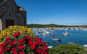 a bunch of boats in a harbor with red flowers at TY KAER - Charmante maison neuve tout confort in Landunvez