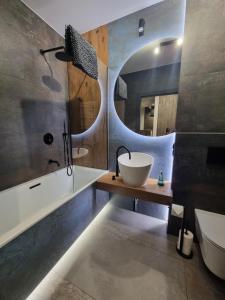 a bathroom with a sink and a mirror at Parkowa Premium Apartment in Gdynia +18 photos