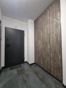 a hallway with a black door and a wall at Parkowa Premium Apartment in Gdynia