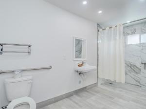 a white bathroom with a toilet and a shower at Alameda Motel San Jose in San Jose +34 photos