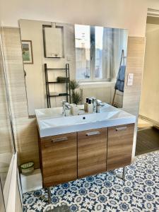 a bathroom with a sink and a large mirror at La belle échappée, maison chic près de lille & Parc Barbieux in Roubaix