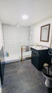 a bathroom with a tub and a sink and a toilet at Powis House East Cottage in Stirling +16 photos