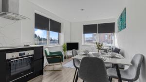 a kitchen and dining room with a table and chairs at Cosy Luxury 2 Bedroom Apartment near NEC & Birmingham Airport in Birmingham