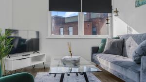 a living room with a couch and a tv at Cosy Luxury 2 Bedroom Apartment near NEC & Birmingham Airport in Birmingham