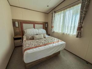 een slaapkamer met een bed en een raam bij Beautiful Caravan With Stunning Sea Views At Haven Hopton Ref 80001H in Great Yarmouth +16 foto's