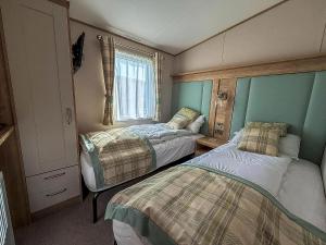 a small room with two beds and a window at Luxury Lodge With Stunning Full Sea Views At Hopton Ref 80010W in Great Yarmouth +24 photos