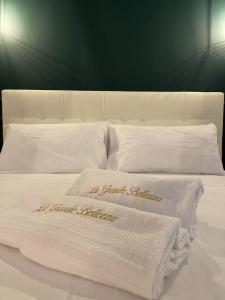 a white bed with two towels on top of it at La Grande Bellezza in Taranto