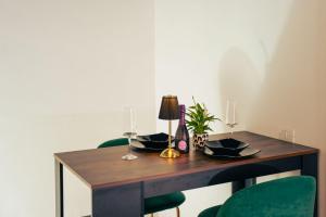 a dining room table with green chairs and a lamp at La Grande Bellezza in Taranto +11 photos