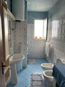 a blue and white bathroom with two toilets and a sink at Vistamar Apartment in Golem