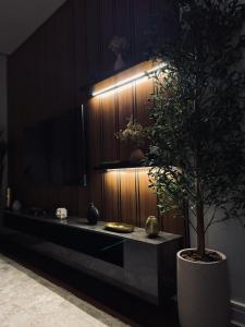 een woonkamer met een tv en een potplant bij luxury apartment AL Majdiah Residence K,Hittin,Boulevard, البوليفارد in Riyad