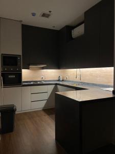een keuken met zwarte kasten en een aanrecht bij luxury apartment AL Majdiah Residence K,Hittin,Boulevard, البوليفارد in Riyad