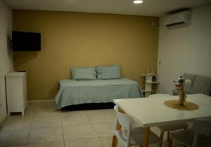 Un dormitorio con una cama con almohadas azules y una mesa. en Complejo Zampa - Moderna casa con Pileta y Parque, en San Rafael 15 fotos más