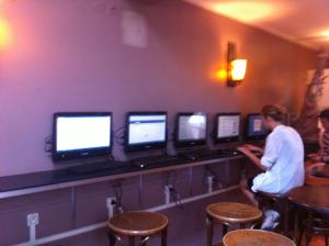 a man standing in front of a row of computer monitors at Aloha Hostel Eiffel Tower by Hiphophostels in Paris