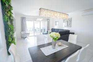 a dining room and living room with a table and chairs at Crystal Adria in Privlaka