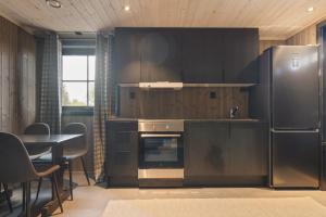 a kitchen with a stainless steel refrigerator and a table at Trysil turistesenter liten leilighet in Trysil