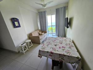 a room with a bed and a couch and a window at Apartamento frente ao mar de Angra in Mangaratiba