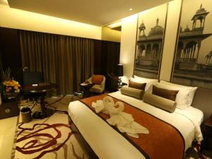 a hotel room with a bed with flowers on it at Pride Plaza Hotel, Aerocity New Delhi in New Delhi