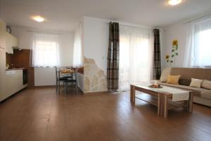 ein Wohnzimmer mit einem Sofa und einem Tisch in der Unterkunft Apartments Lili in Klimno