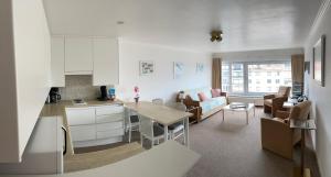 een keuken en een woonkamer met een tafel bij Zonnige studio Mermoz Koksijde-Bad in Koksijde