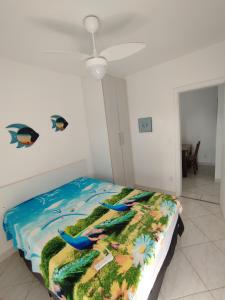 a bed with a colorful comforter in a room at terraços do maitinga in Bertioga +54 photos