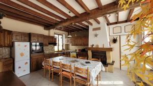 a kitchen with a table with chairs and a refrigerator at Gîtes en Pays d'Othe in Druisy