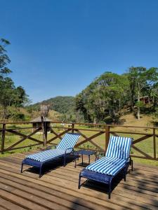 two blue chairs sitting on a wooden deck at A Luz Azul - Pousada e Gastronomia in Bananal
