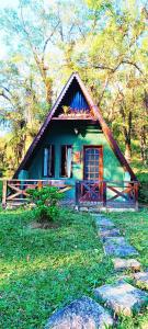 a small green house with a pathway in front of it at A Luz Azul - Pousada e Gastronomia in Bananal