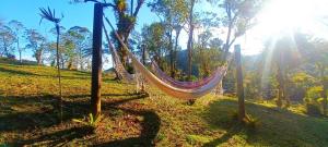 a hammock on a hill in a field at A Luz Azul - Pousada e Gastronomia in Bananal +1 photo
