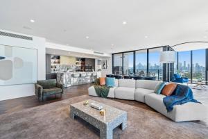 a living room with a couch and a table at Complete Host Nine Elm Apartments in Melbourne
