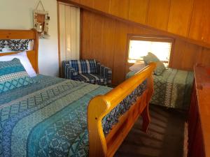 a bedroom with a bed and a chair in a room at Knott Lakeview in Bass Lake