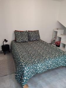 a bedroom with a bed with a green blanket and pillows at Maison 115 m 2 avec Jardin in Carignan +15 photos