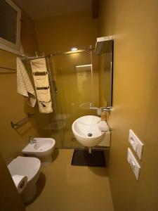 a bathroom with a sink and a toilet and a shower at Le Casette di Elen in Marsala