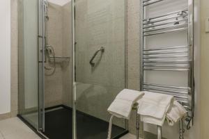 un bagno con doccia in vetro e asciugamani su uno sgabello di Casa da Tapa 7 a Vila Pouca de Aguiar Altre 89 foto