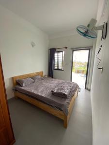 Phú Quí (2)にあるChill Garden Homestay Near Beach Tam Thanhの窓のある部屋にベッドがある寝室