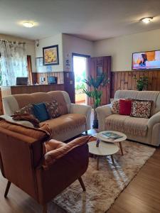 a living room with two couches and a table at Pousada Sino dos Ventos in Campos do Jordão