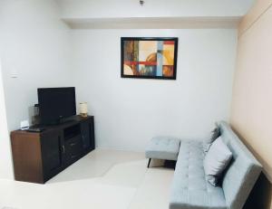 a living room with a couch and a tv at Suite Escapade in Manila