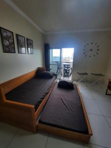 a bedroom with two large beds and a clock on the wall at Apto com 4 camas no bairro do Reduto in Belém