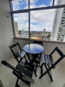 two chairs and a table in a room with a window at Apto com 4 camas no bairro do Reduto in Belém