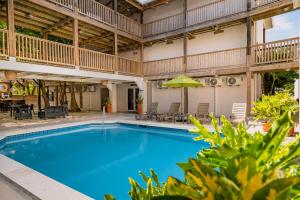 a large swimming pool with a large building with a patio at Bananas On The Beach in San Pedro