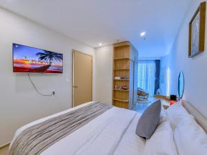 a bedroom with a large bed and a tv on the wall at A cozy condotel in Bai Sau(1 bed and 1 sofa bed) in Vung Tau +30 photos