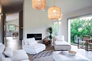 カステッリーナ・マリッティマにあるVilla La Leccina a Castellina Marittimaの白い家具と大きな窓のあるリビングルーム