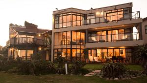 a large house with a lot of windows at Supertubes Guesthouse in Jeffreys Bay