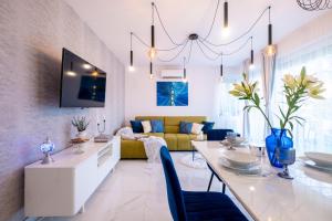 a living room with a white table and a yellow couch at White Rose Hill Luxury Apartment Budapest in Budapest