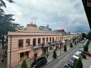 a building on a street with cars parked on the street at Hotel Metropol Batumi in Batumi
