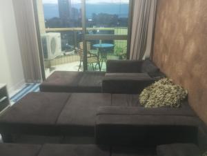 a living room with two couches and a balcony at Apartamento T-44 com Vista para o Mar 50 metros da Praia Mongaguá Piscina Wi-Fi in Mongaguá