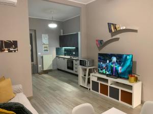 a living room with a television and a kitchen at Casa Virgilio in Venosa