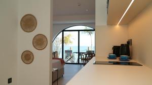 a kitchen and living room with a view of the ocean at Sirena Bay Beach House and Luxury Suites in Protaras