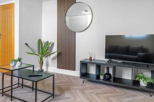 een woonkamer met twee zwarte tafels en een spiegel bij St George's Quarter - Luxury Stays - Duplex - FREE PARKING - Home From Home - FREE WIFI - Newly Renovated - Moorfeilds in Liverpool